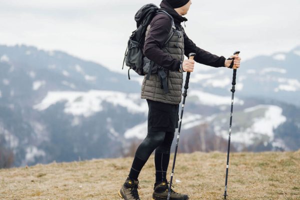 muž kráča s expeditionskými palicami